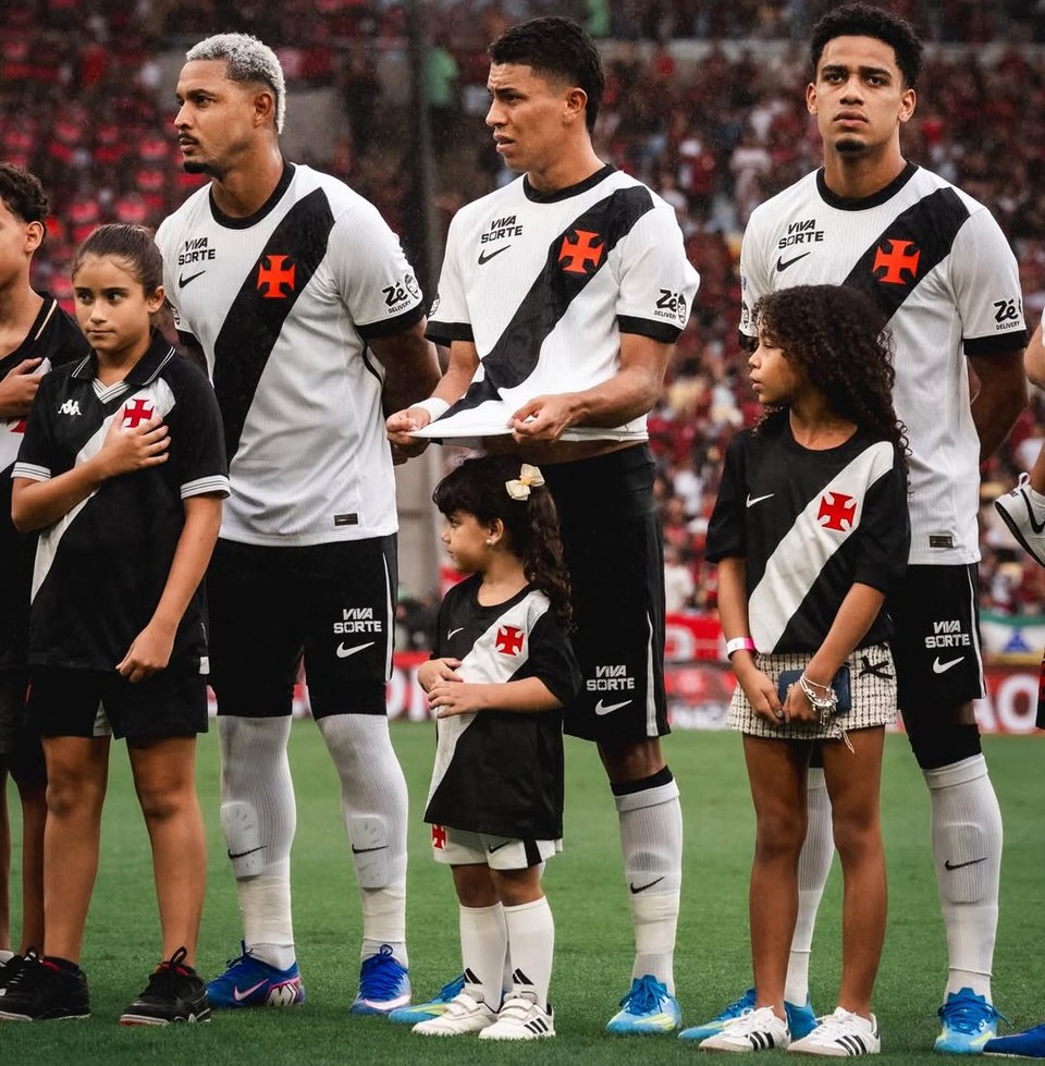Rojas protege pequena vascaína da chuva com sua camisa antes do clássico
